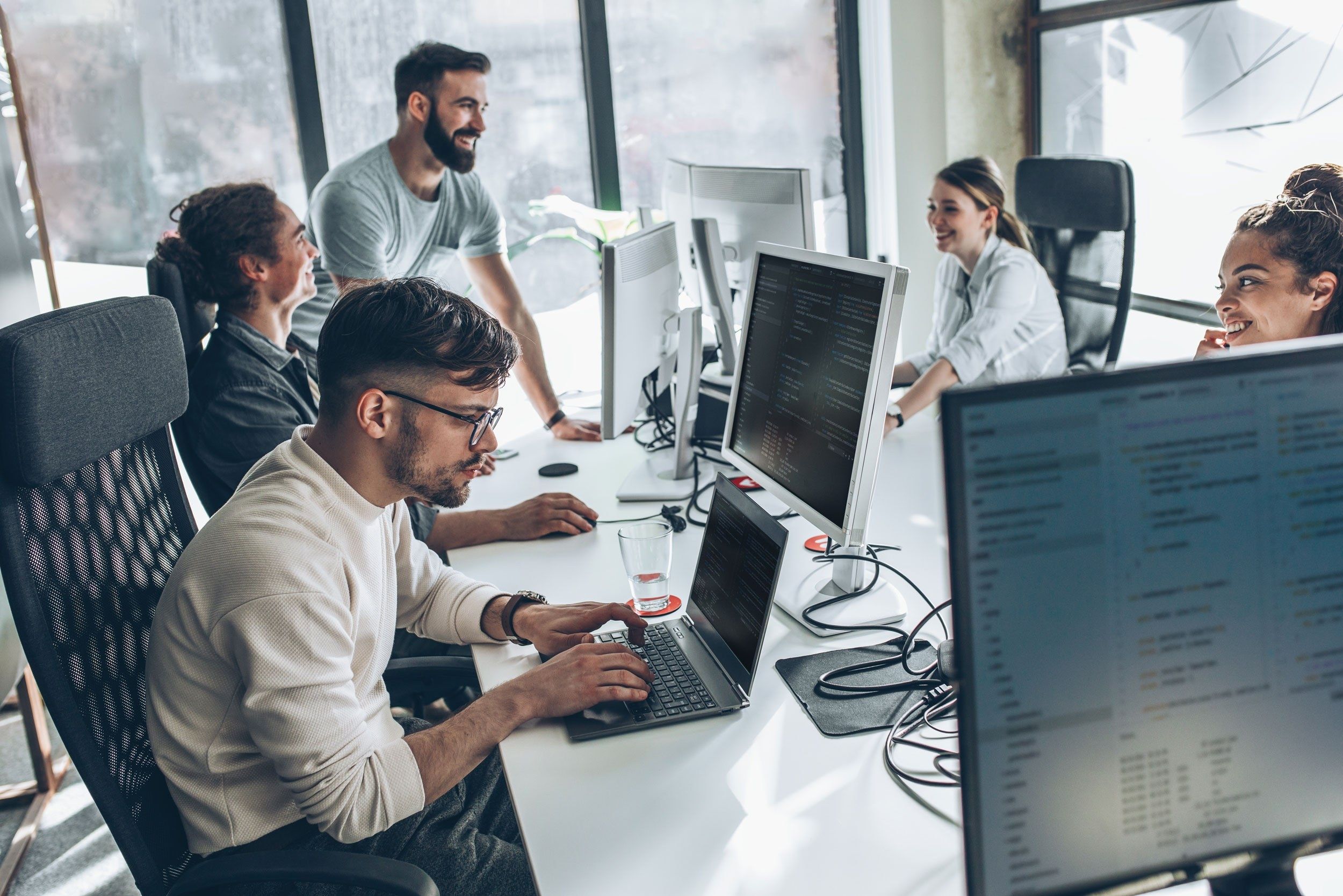 A data team working at their desks in a bright office