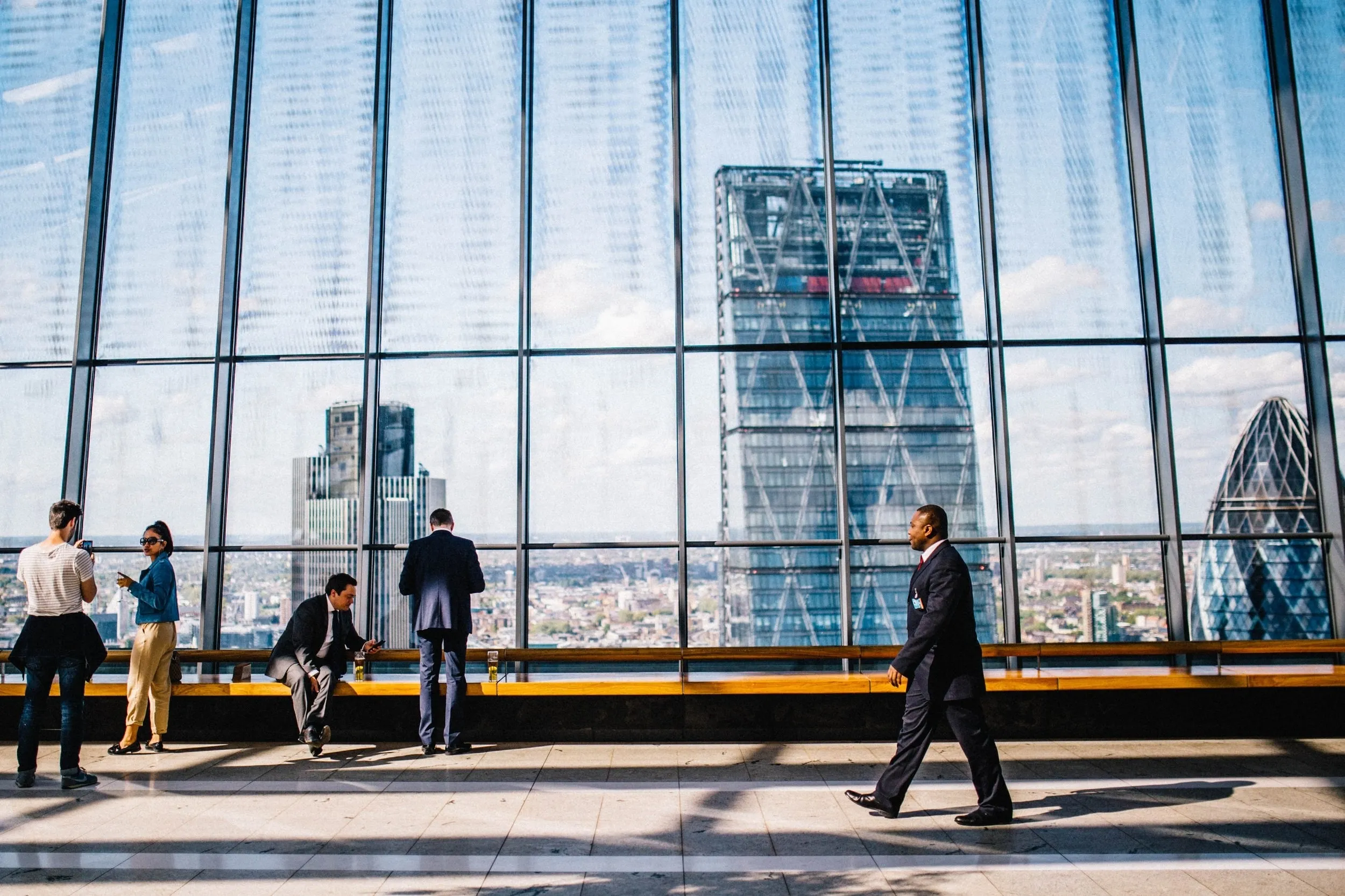 People at a window overlooking the City of London skyline