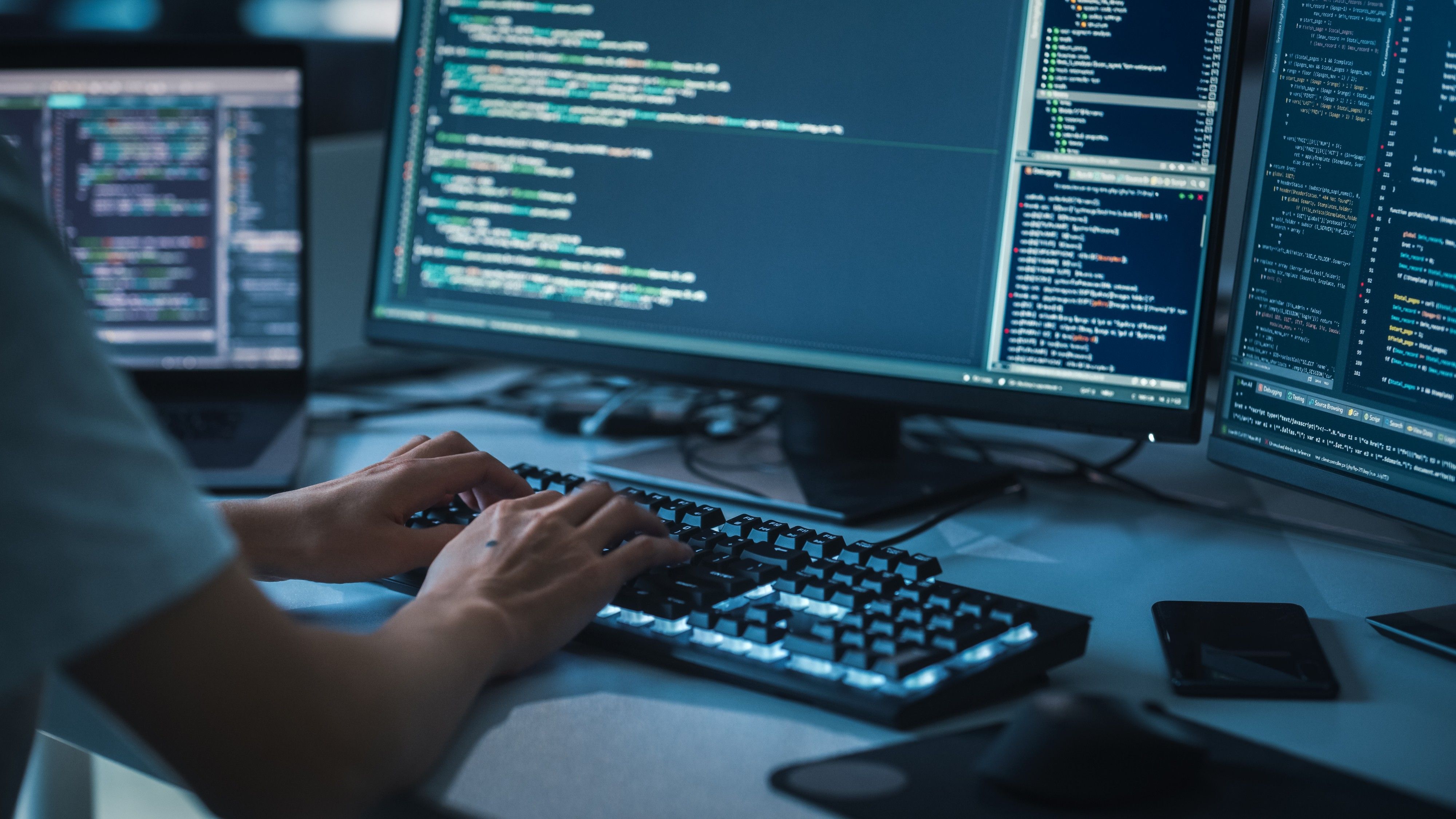 Code on a developer's monitors
