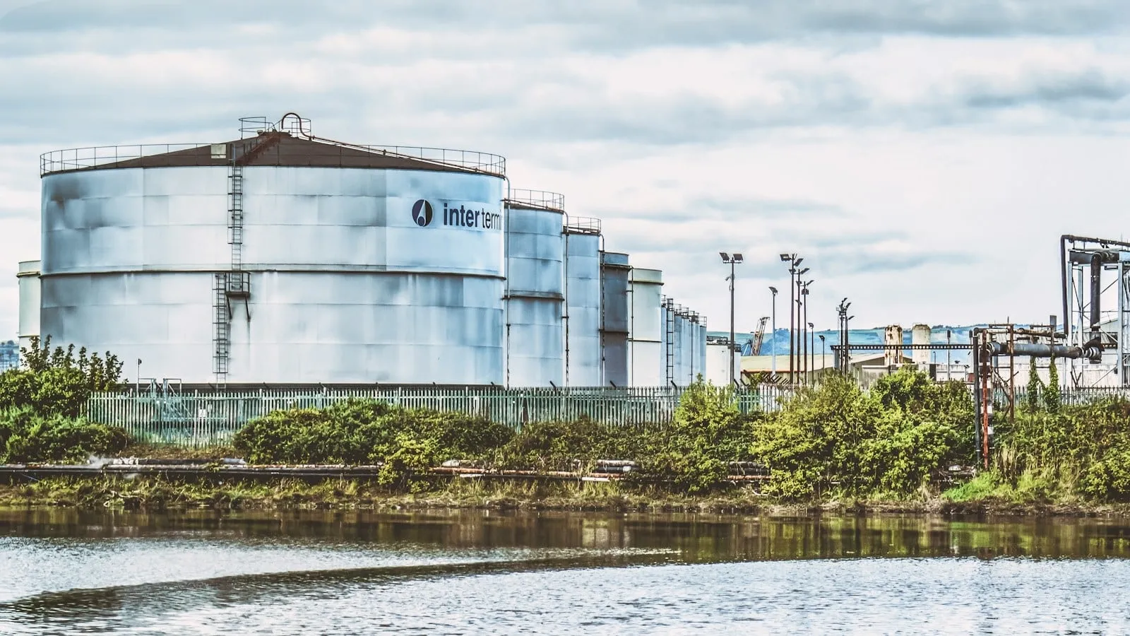 Industrial chemical storage tanks beside a river