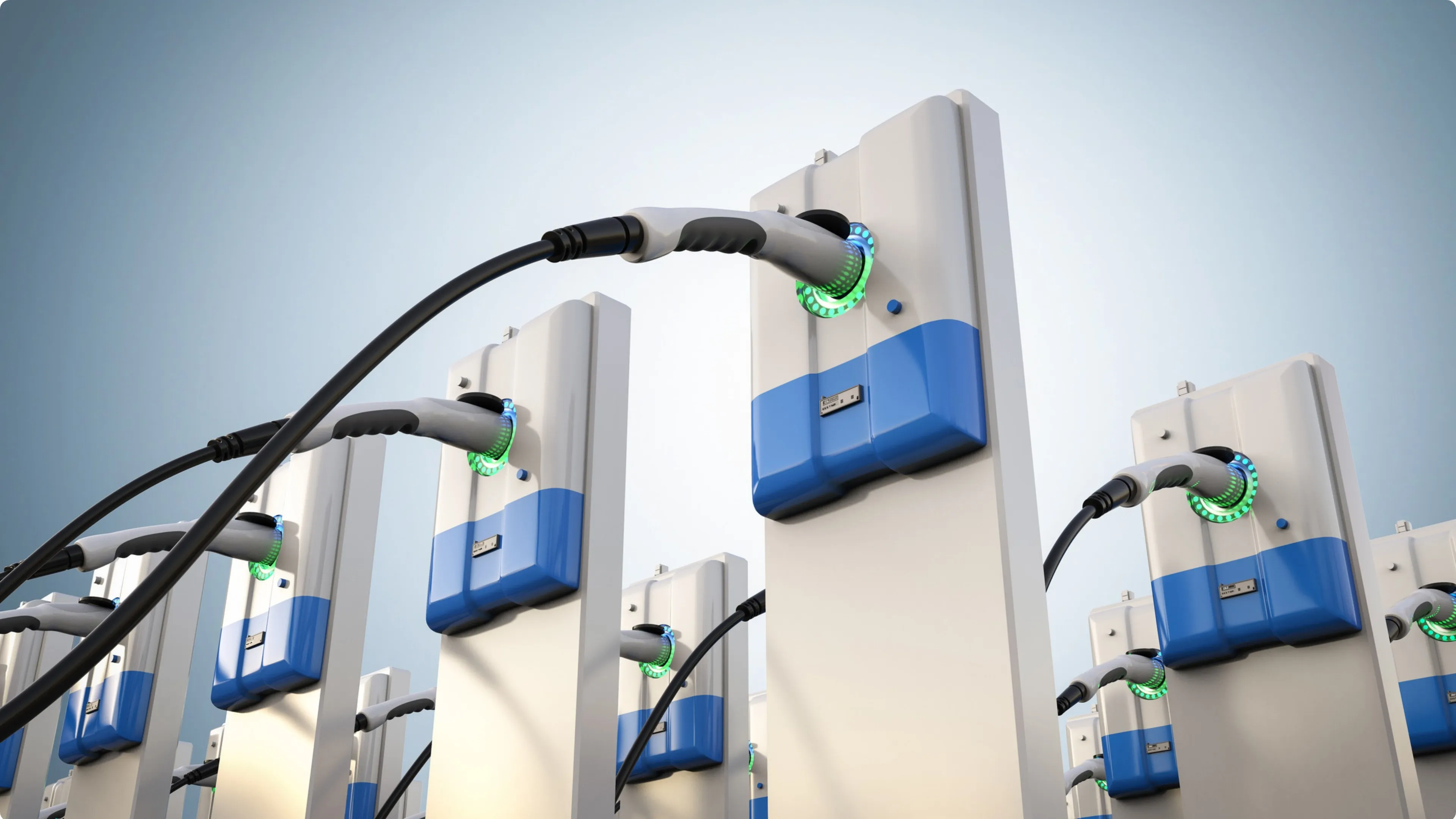A row of electric vehicle chargers with glowing green rings
