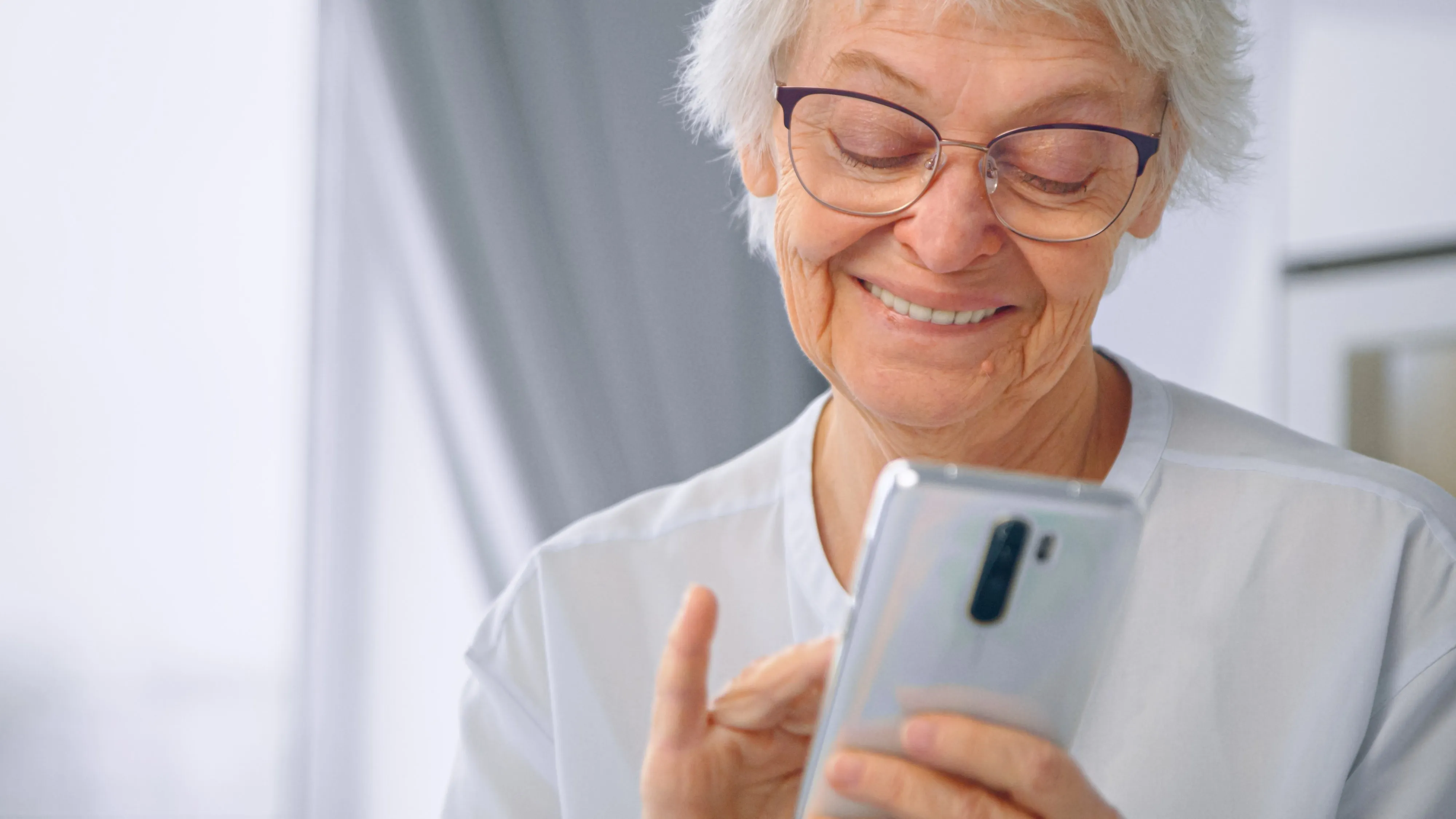 An older woman using her phone at home