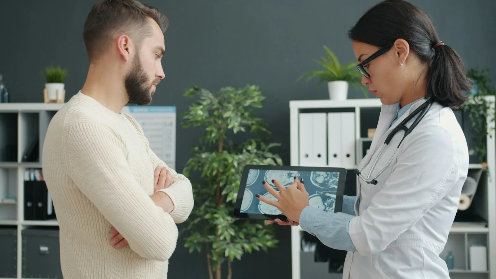 A doctor showing a scan on a tablet to a patient