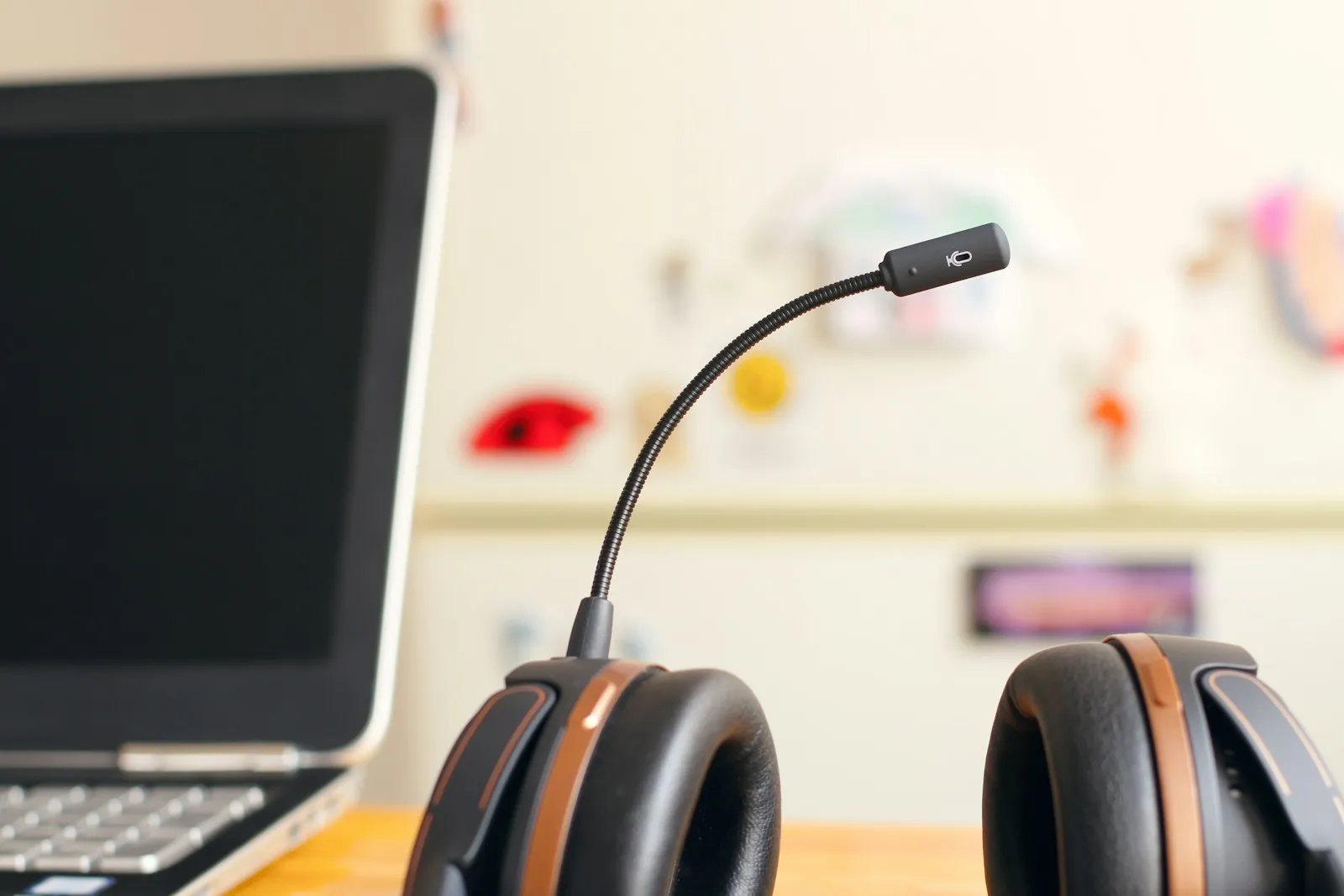 A headset beside a laptop on a desk