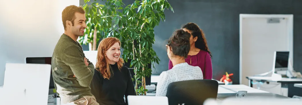Colleagues talking together in a bright open office