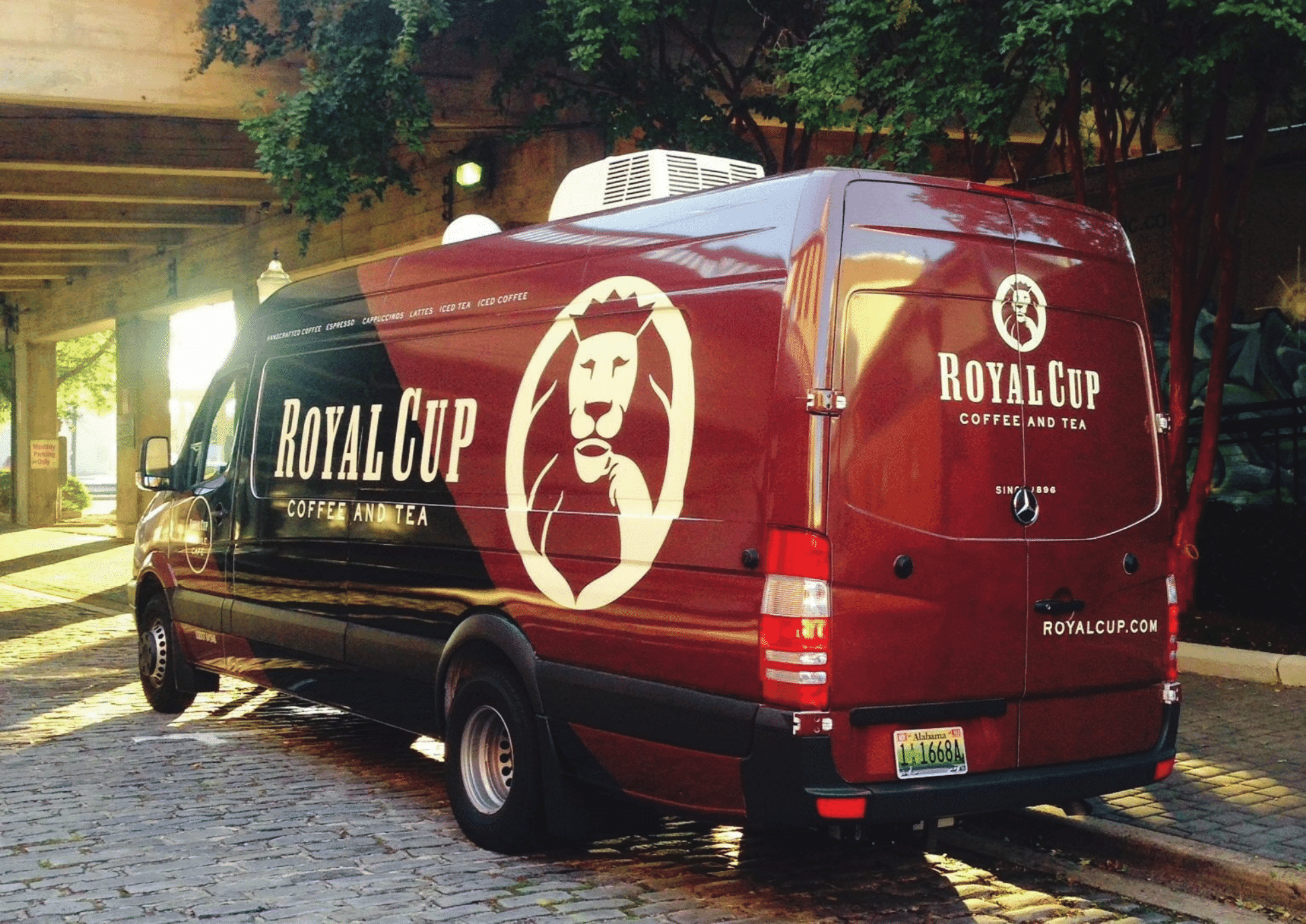 A Royal Cup Coffee and Tea delivery van parked on a cobblestone street