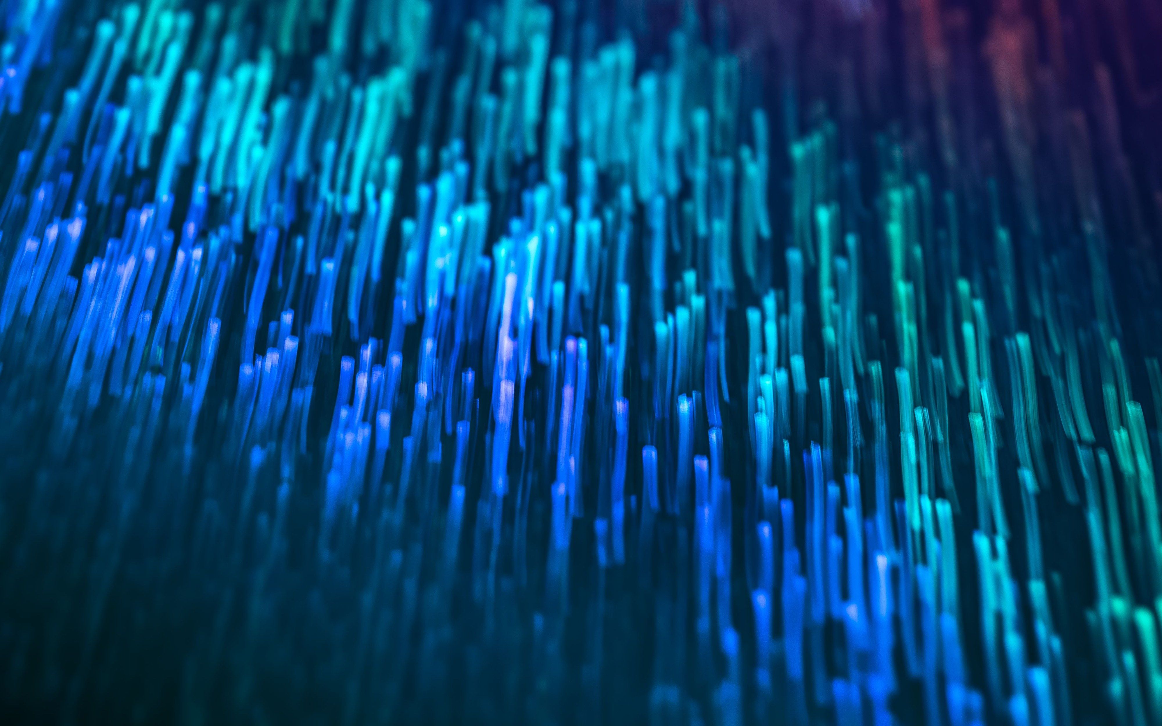 Streaks of blue and green light across a dark background