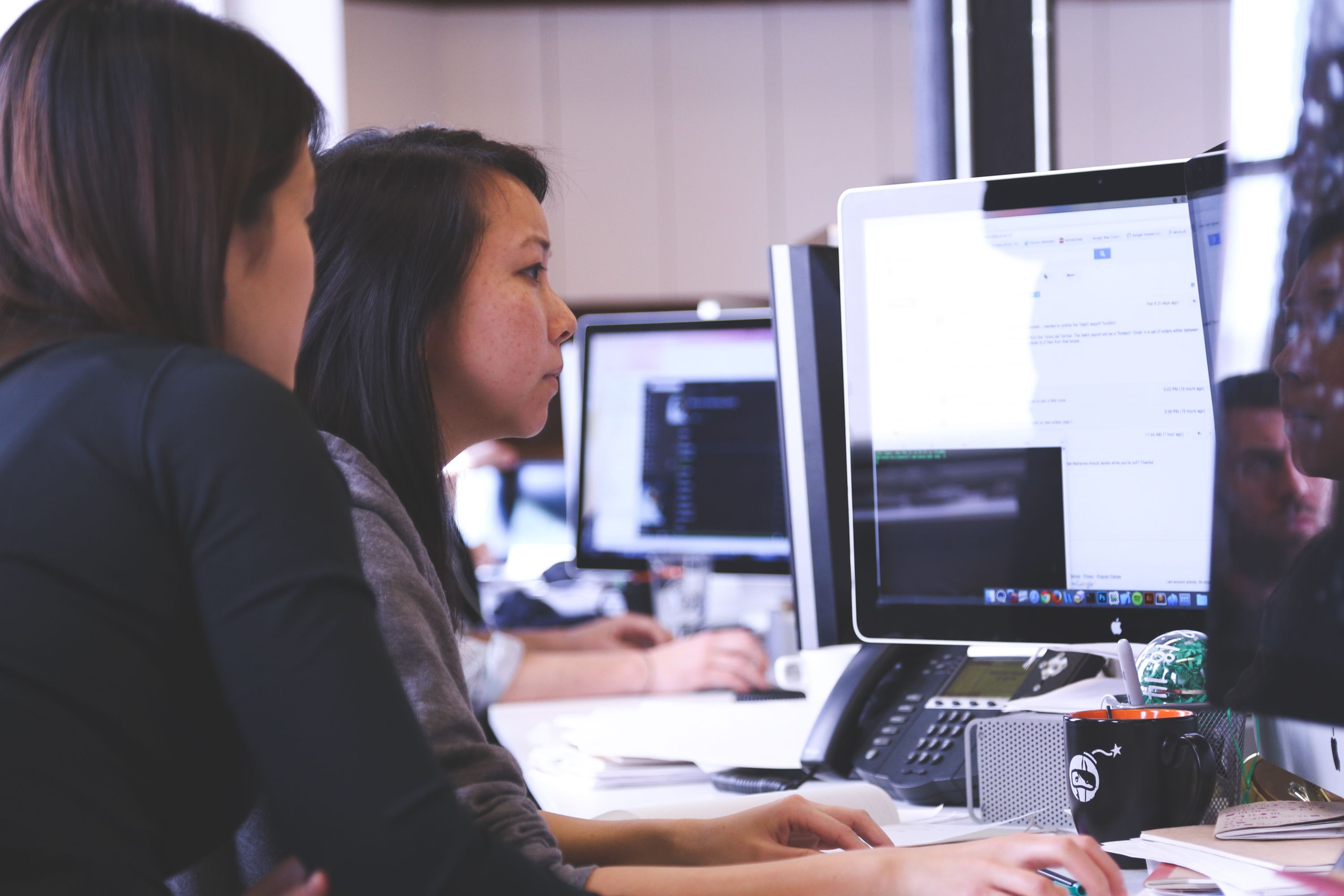 Two engineers reviewing code together at their screens