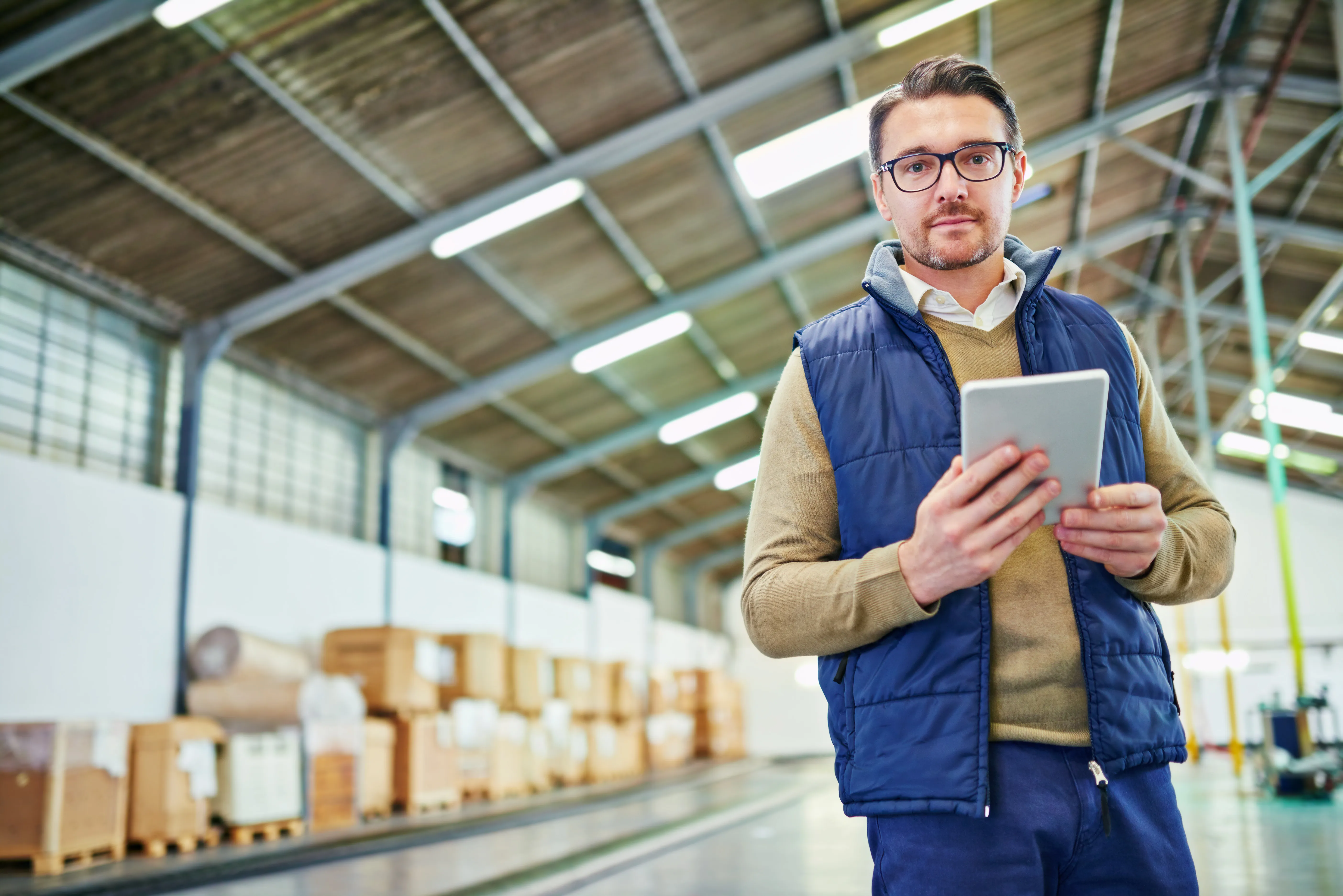 A warehouse manager holding a tablet